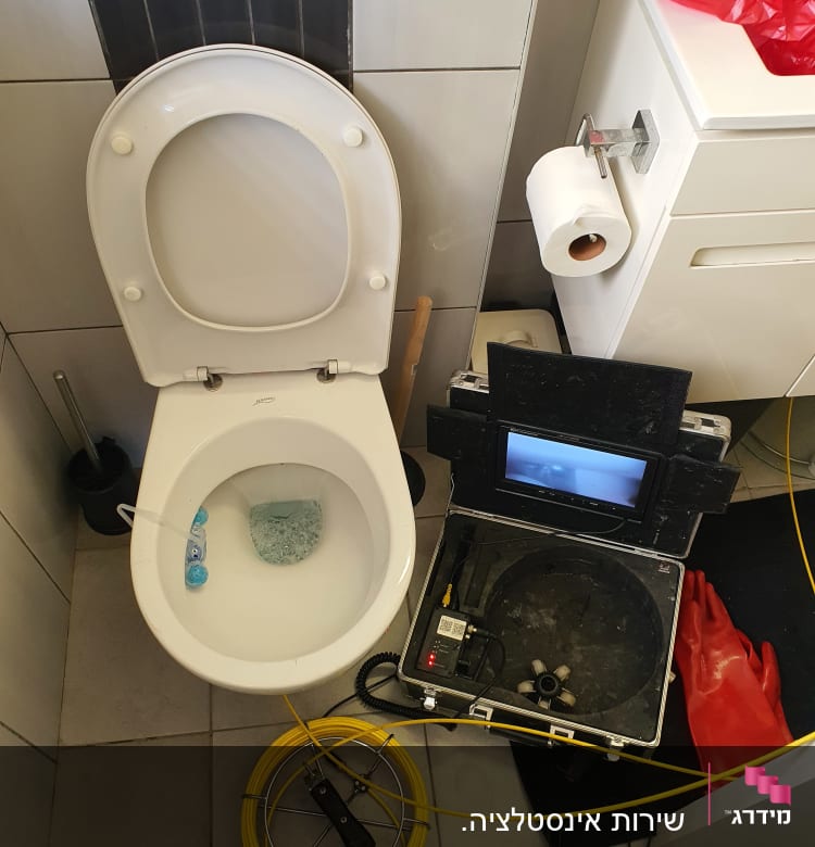 ציוד אינסטלציה כולל מצלמה, כפפות אדומות וחוט צהוב